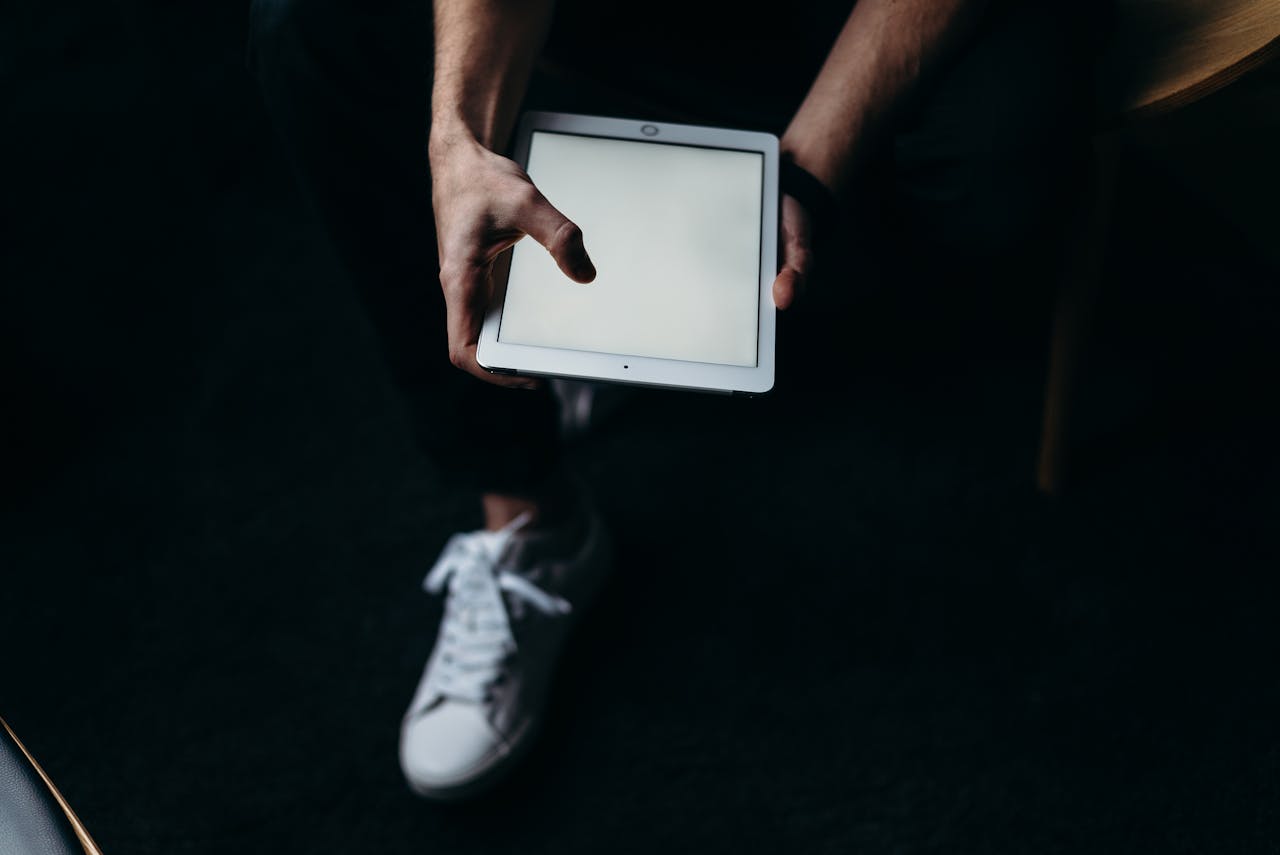 Hands holding a blank screen tablet indoors, ideal for tech and business concepts.
